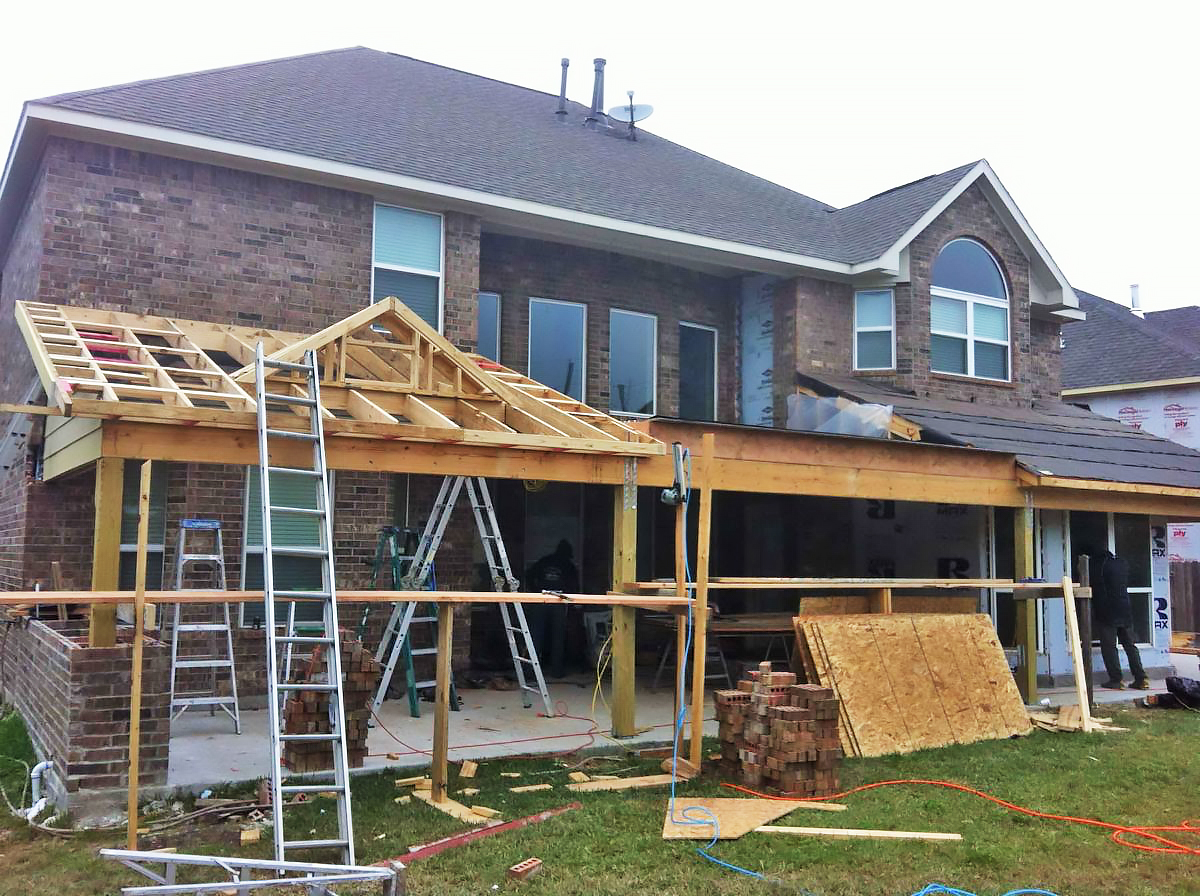 patio construction background showing crew working on exterior patio cover in Houston Texas