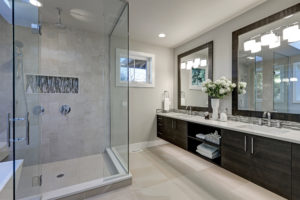 Specious remodeled master bathroom with glass shower and detailed wood cabinets 